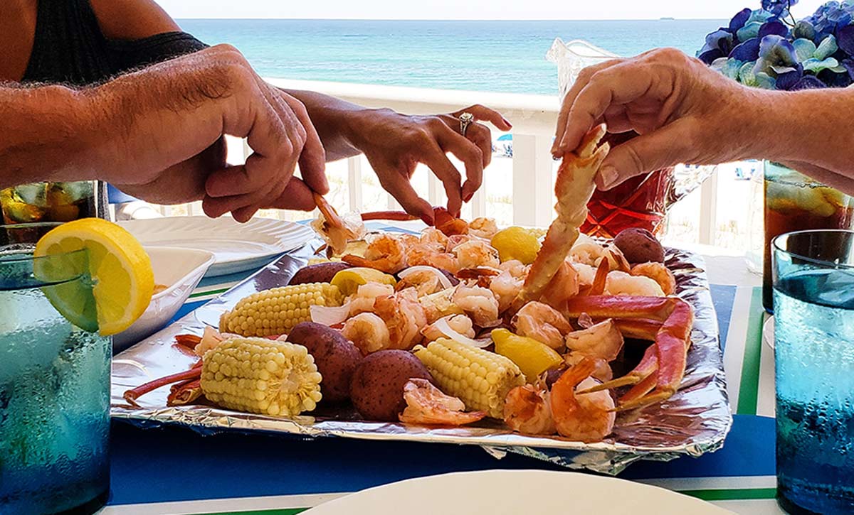 family enjoying beachside seafood boil